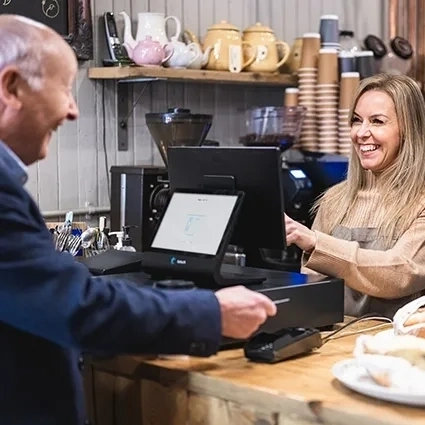 Kunde tätigt eine zahlung an einer cafe theke mit einem touchscreen kassensystem
